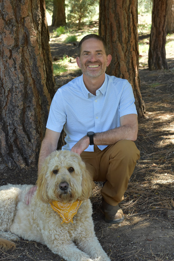 Man crouched by dog